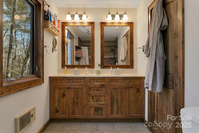 full bathroom featuring tile patterned floors, visible vents, double vanity, and a sink