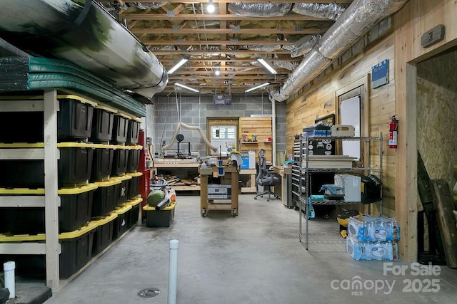 basement with a workshop area and concrete block wall