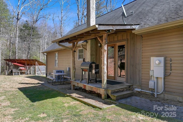 exterior space featuring a yard and a shingled roof