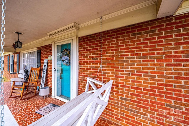 property entrance with brick siding and covered porch