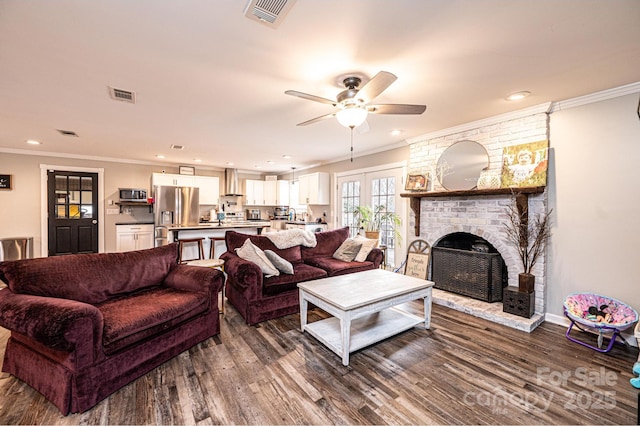 living area featuring visible vents, dark wood-type flooring, and crown molding