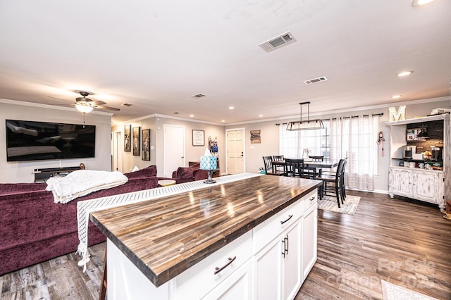 kitchen with open floor plan, visible vents, and wood counters