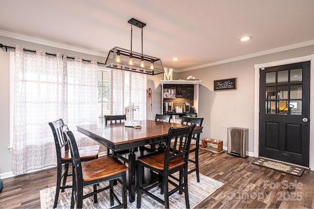 dining area featuring baseboards, dark wood-style flooring, and crown molding