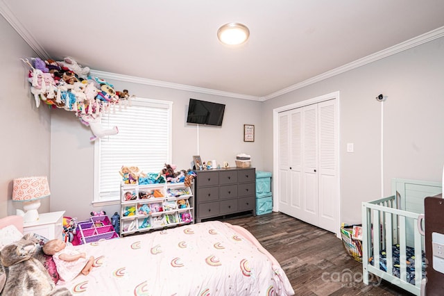 bedroom with dark wood-style floors, crown molding, and a closet