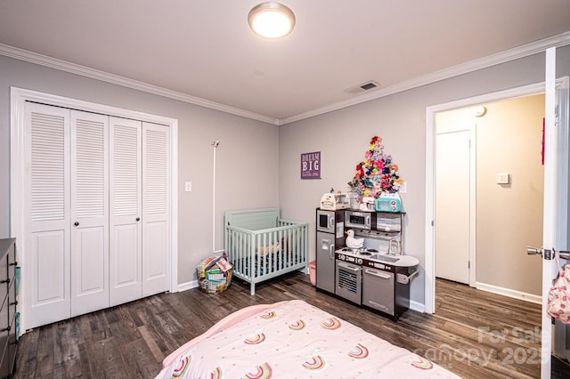 bedroom featuring visible vents, a closet, wood finished floors, and crown molding