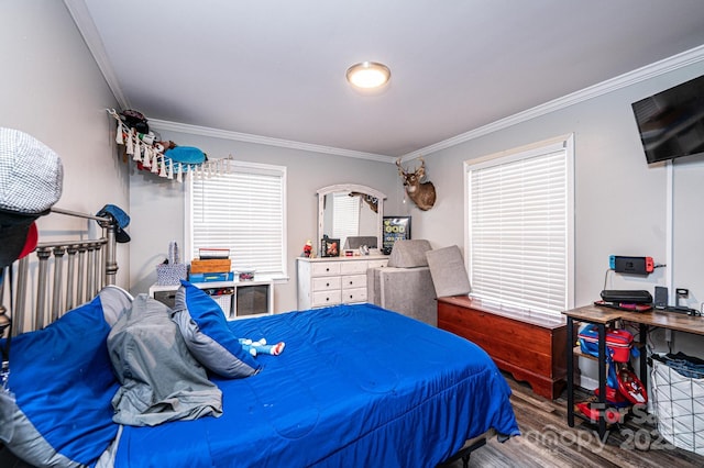 bedroom with wood finished floors and crown molding