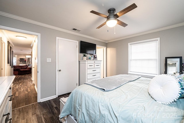 bedroom with dark wood finished floors, visible vents, baseboards, and ornamental molding