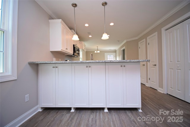 kitchen with light stone countertops, a peninsula, white cabinetry, and ornamental molding