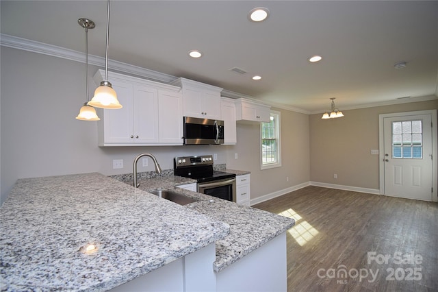 kitchen with a peninsula, a sink, ornamental molding, stainless steel appliances, and white cabinets