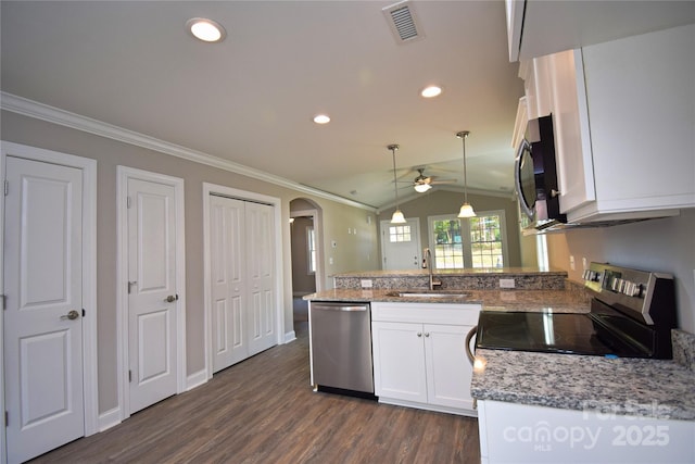 kitchen with a peninsula, arched walkways, a sink, stainless steel appliances, and crown molding