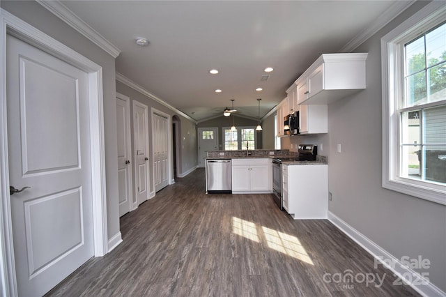 kitchen with a wealth of natural light, appliances with stainless steel finishes, ornamental molding, and white cabinetry