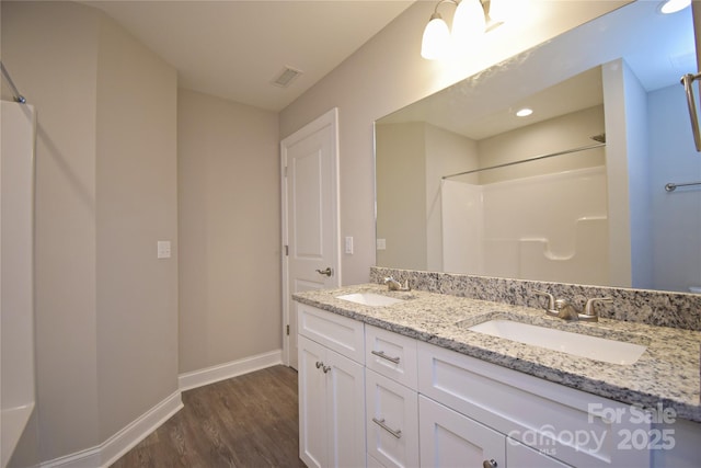 full bath featuring visible vents, wood finished floors, walk in shower, and a sink