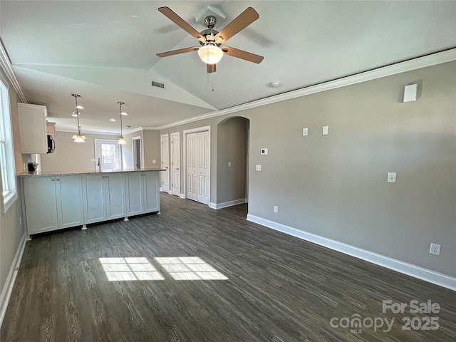 kitchen with visible vents, vaulted ceiling, ornamental molding, a peninsula, and arched walkways