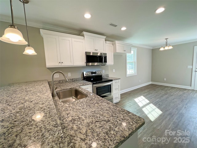 kitchen with visible vents, crown molding, white cabinets, stainless steel appliances, and a sink