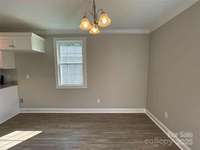 unfurnished dining area with a notable chandelier, dark wood-type flooring, baseboards, and ornamental molding