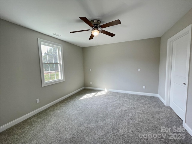 unfurnished room with visible vents, baseboards, carpet, and ceiling fan