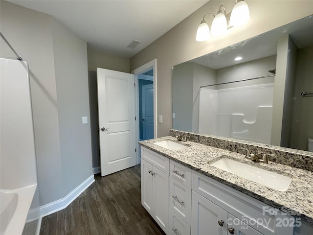 bathroom featuring a sink, visible vents, a shower, and wood finished floors