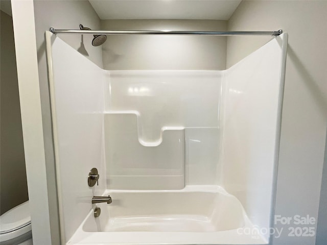 bathroom with shower / bathing tub combination and toilet