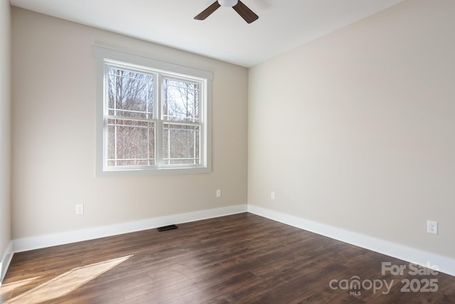 unfurnished room featuring visible vents, dark wood-style floors, baseboards, and ceiling fan