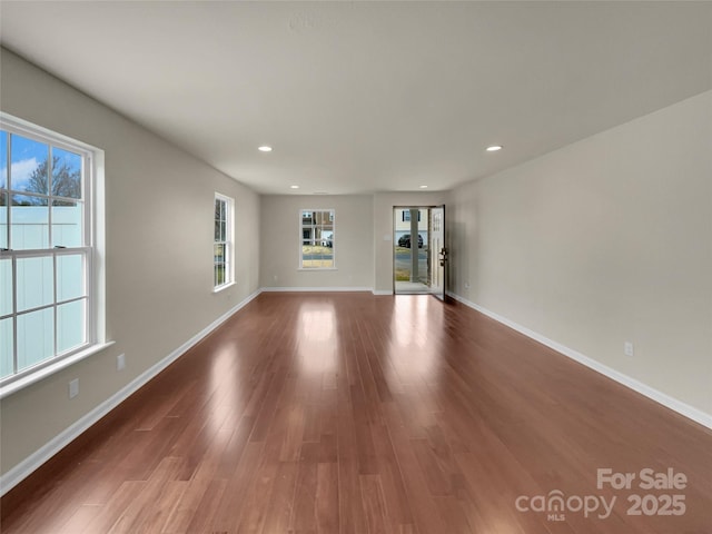 unfurnished living room featuring recessed lighting, baseboards, and wood finished floors