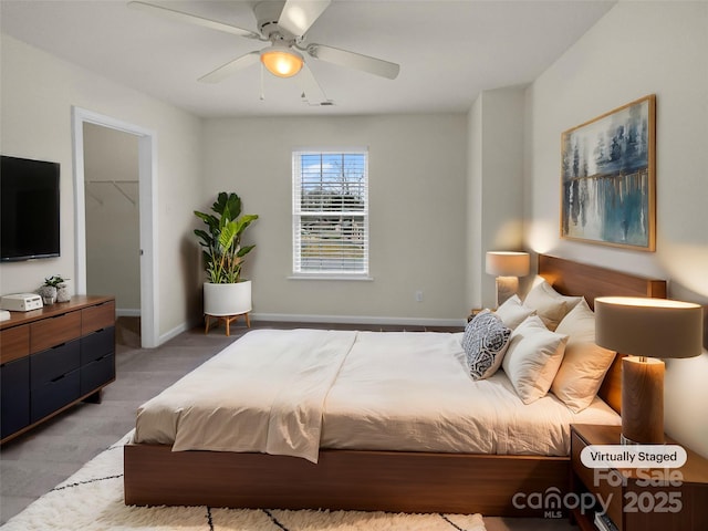 bedroom with baseboards, ceiling fan, and a spacious closet