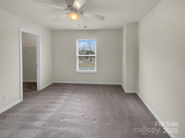 carpeted empty room with baseboards and ceiling fan