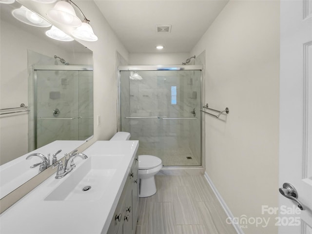 bathroom featuring visible vents, baseboards, toilet, a stall shower, and vanity