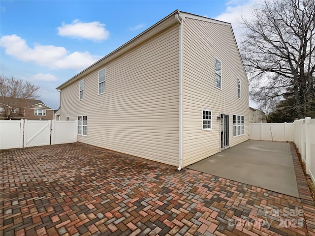 view of home's exterior with a patio, a gate, and a fenced backyard