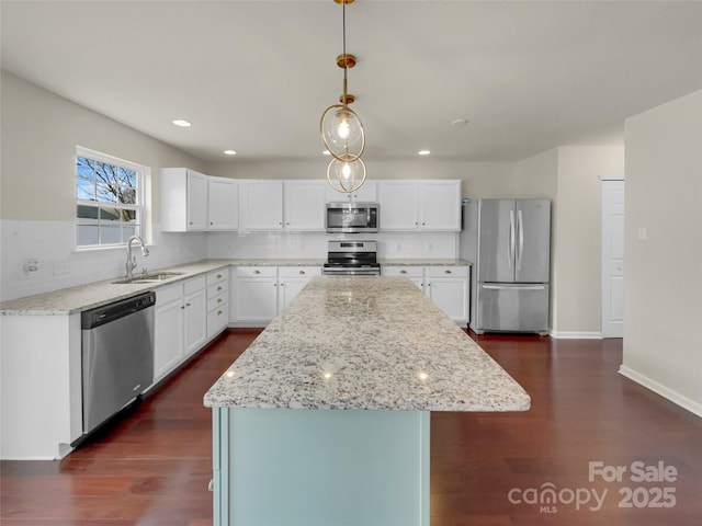 kitchen with light stone counters, dark wood-style floors, a sink, stainless steel appliances, and tasteful backsplash