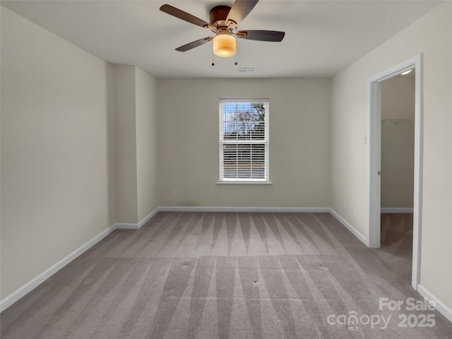 empty room with visible vents, ceiling fan, baseboards, and carpet floors