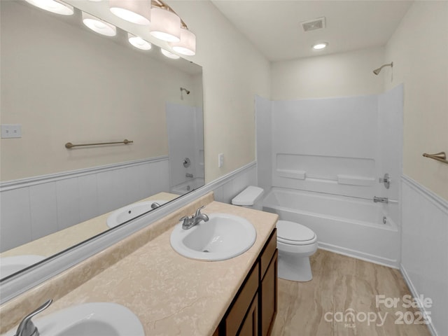 full bathroom with a wainscoted wall, visible vents, shower / bathtub combination, and a sink