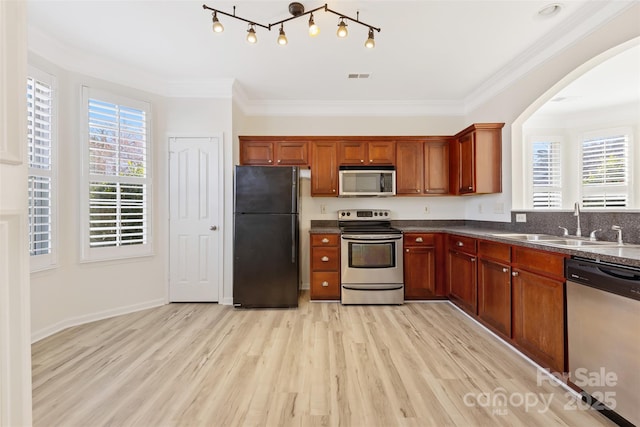 kitchen featuring a sink, stainless steel appliances, dark countertops, and visible vents