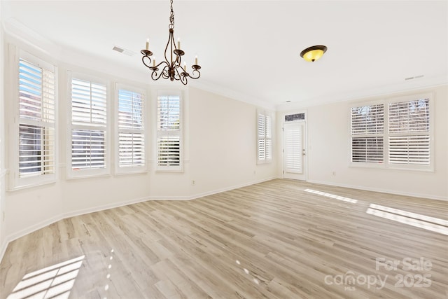 unfurnished dining area featuring visible vents, baseboards, ornamental molding, an inviting chandelier, and light wood-style floors