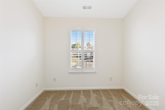 unfurnished room with visible vents, baseboards, and carpet