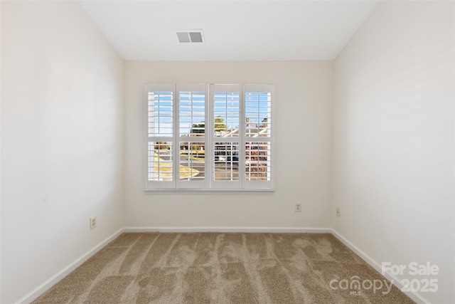 carpeted spare room featuring visible vents and baseboards