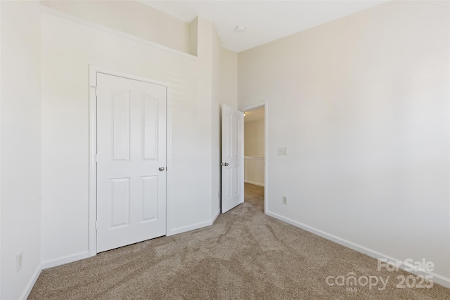 unfurnished bedroom with baseboards and carpet