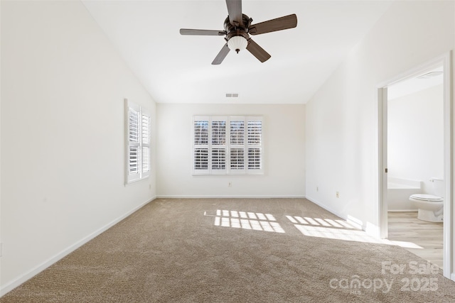 unfurnished bedroom featuring vaulted ceiling, carpet, visible vents, and baseboards