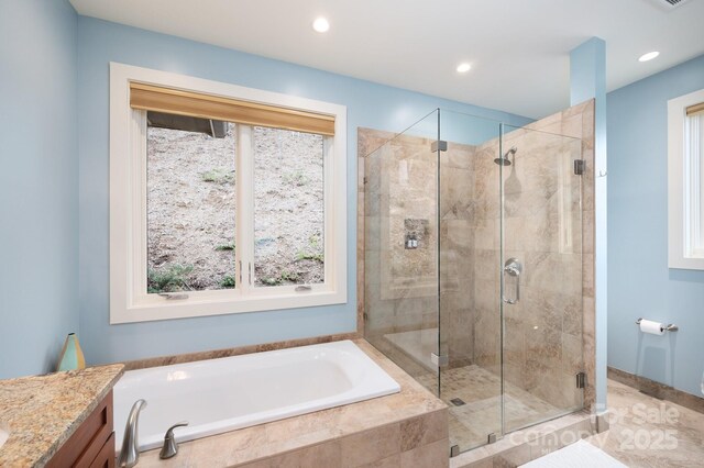 bathroom with recessed lighting, vanity, a bath, and a shower stall