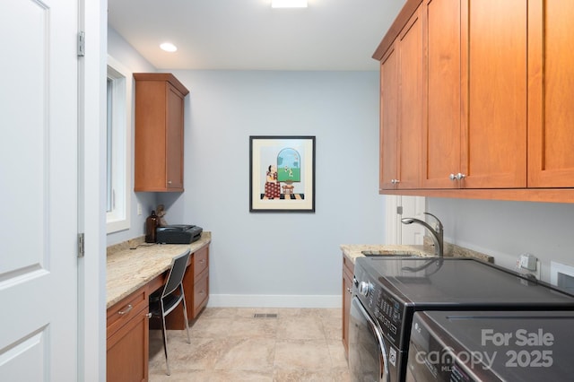 clothes washing area featuring baseboards, visible vents, separate washer and dryer, cabinet space, and a sink