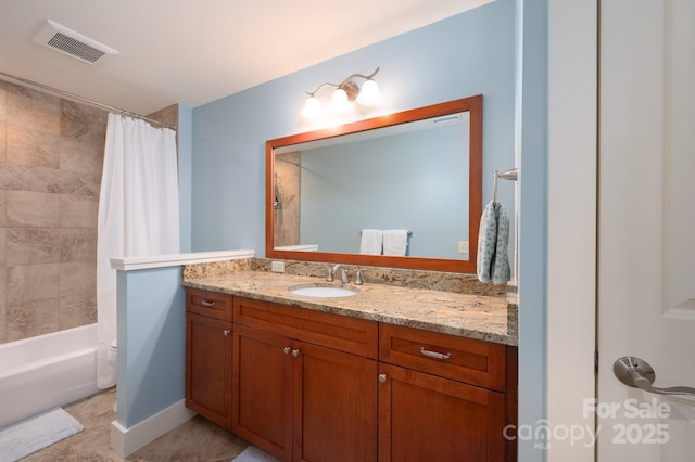 bathroom featuring vanity, shower / bath combo, visible vents, and baseboards