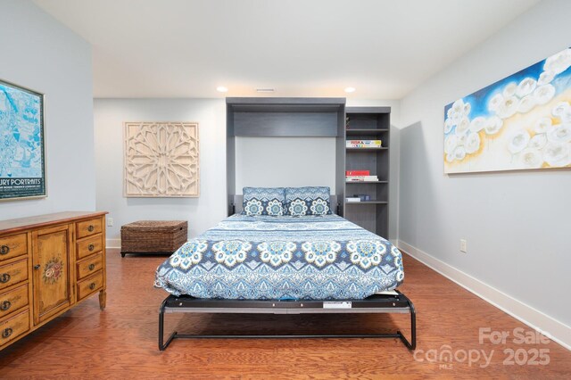 bedroom with recessed lighting, wood finished floors, and baseboards