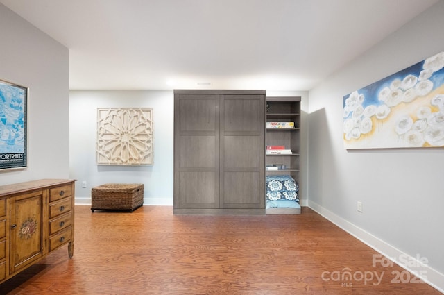 bedroom featuring baseboards and wood finished floors