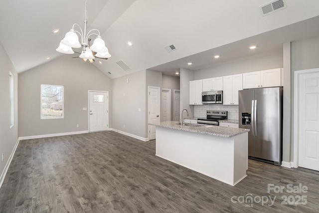 kitchen featuring visible vents, appliances with stainless steel finishes, an island with sink, and white cabinets