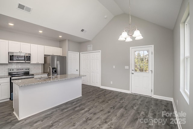 kitchen with visible vents, dark wood-type flooring, an island with sink, appliances with stainless steel finishes, and a sink