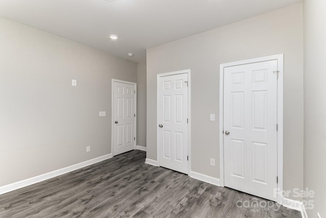 unfurnished bedroom featuring baseboards and wood finished floors