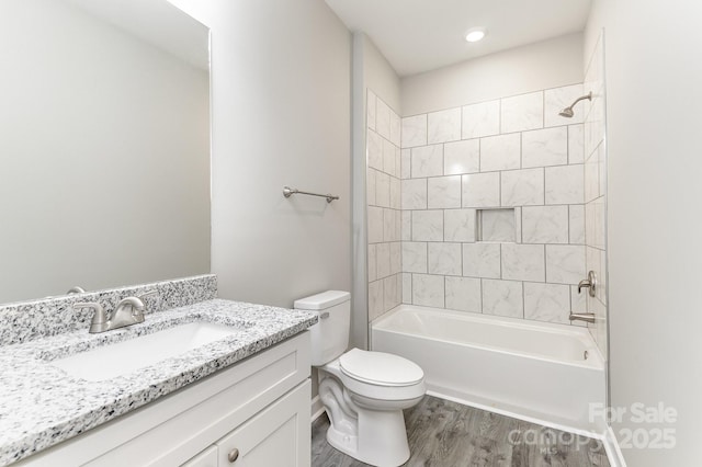 bathroom featuring vanity, toilet, shower / tub combination, and wood finished floors