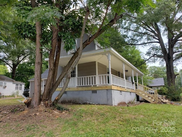 view of front of house featuring crawl space, a porch, a front yard, and stairway