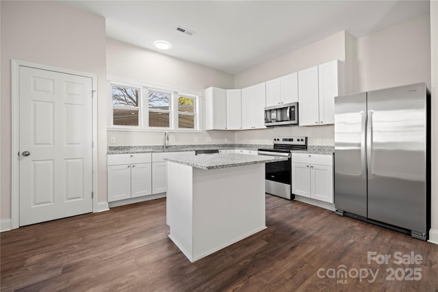 167 Saluda St, Chester, SC 29706 - kitchen with stainless steel appliances, white cabinets, and dark wood-style flooring