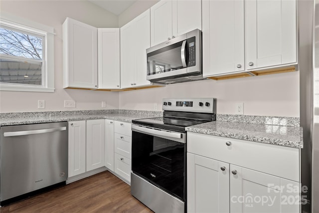 kitchen featuring white cabinets, light stone counters, dark wood-style flooring, and stainless steel appliances