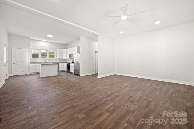 unfurnished living room featuring recessed lighting, baseboards, ceiling fan, and dark wood-style flooring